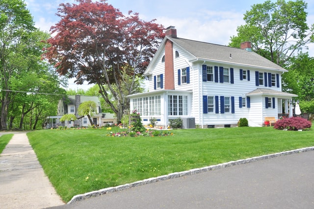 white two story house green lawn